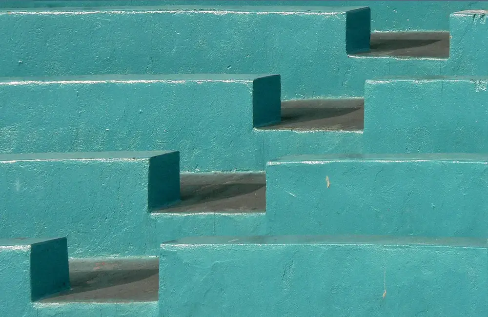 Stacked teal blocks of different sizes on a plain background