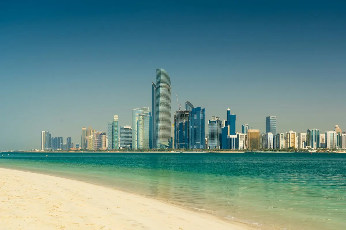The Abu Dhabi skyline seen across the water, with towers rising behind the corniche