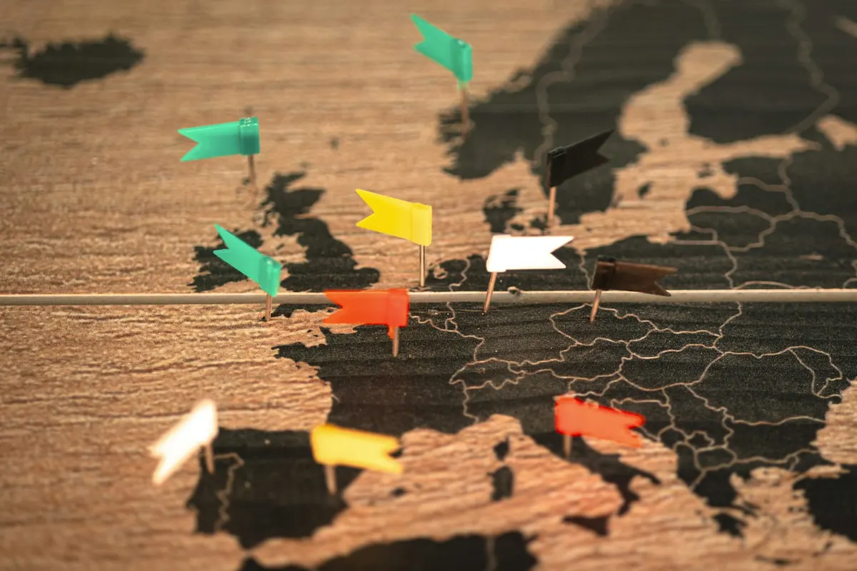 Wooden wall map of Europe marked with colorful location pins
